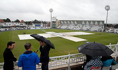 General view of the pitch covered as rain delays play alt=